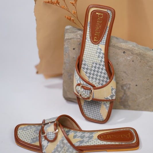 Pair of patterned sandals with brown straps on a neutral background