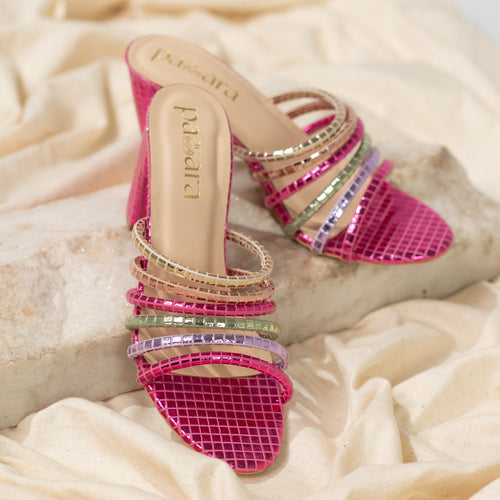 Colorful high-heeled sandals with rhinestone embellishments on a beige fabric background