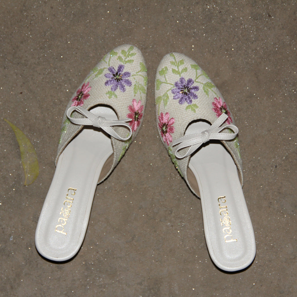 Pair of floral slippers with 'Birkenstock' branding on a concrete surface.