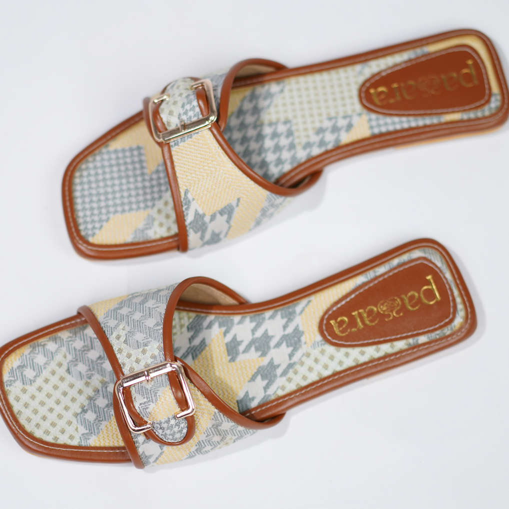 Pair of patterned sandals with brown straps on a white background