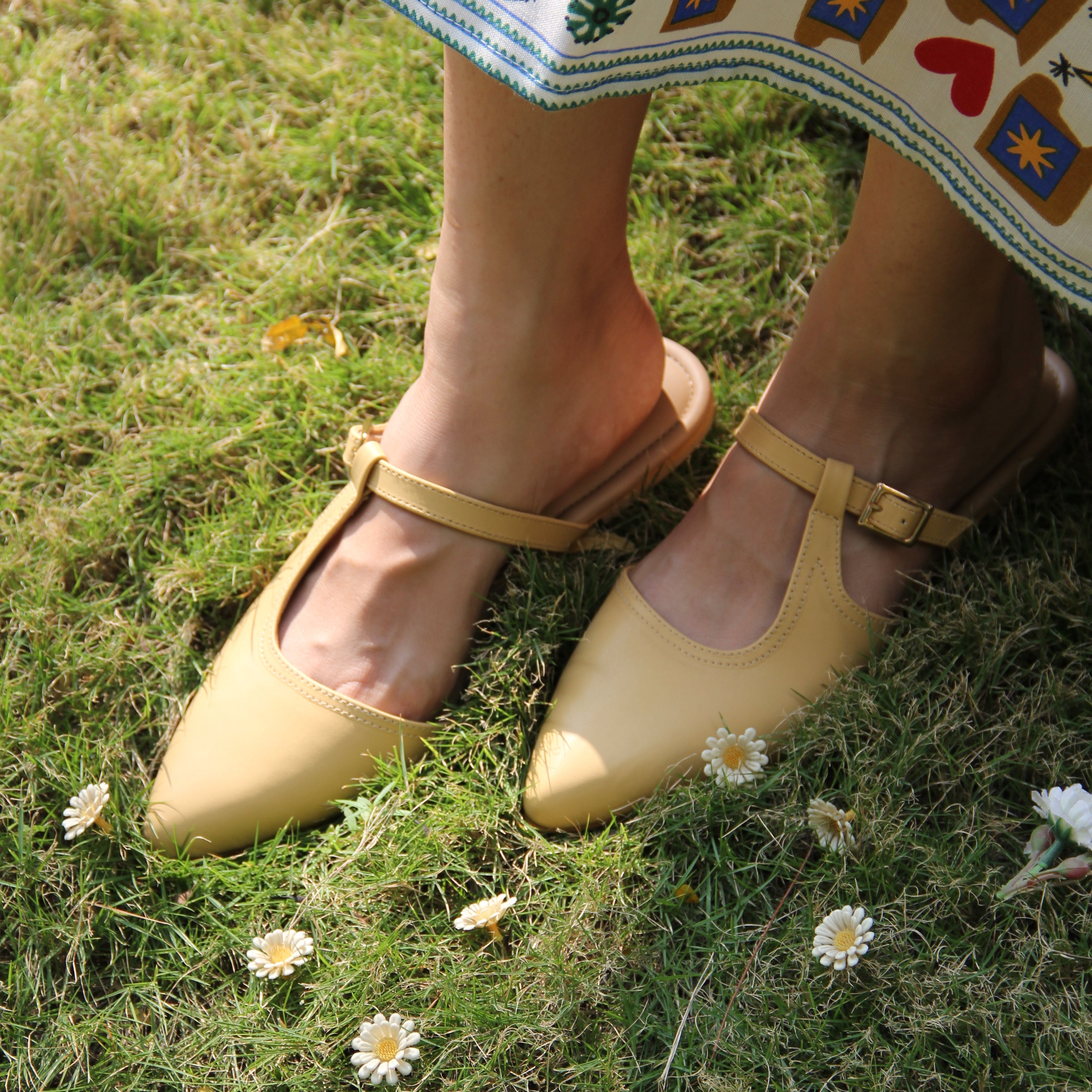 Yellow shoes on grass with a colorful shoe in the foreground